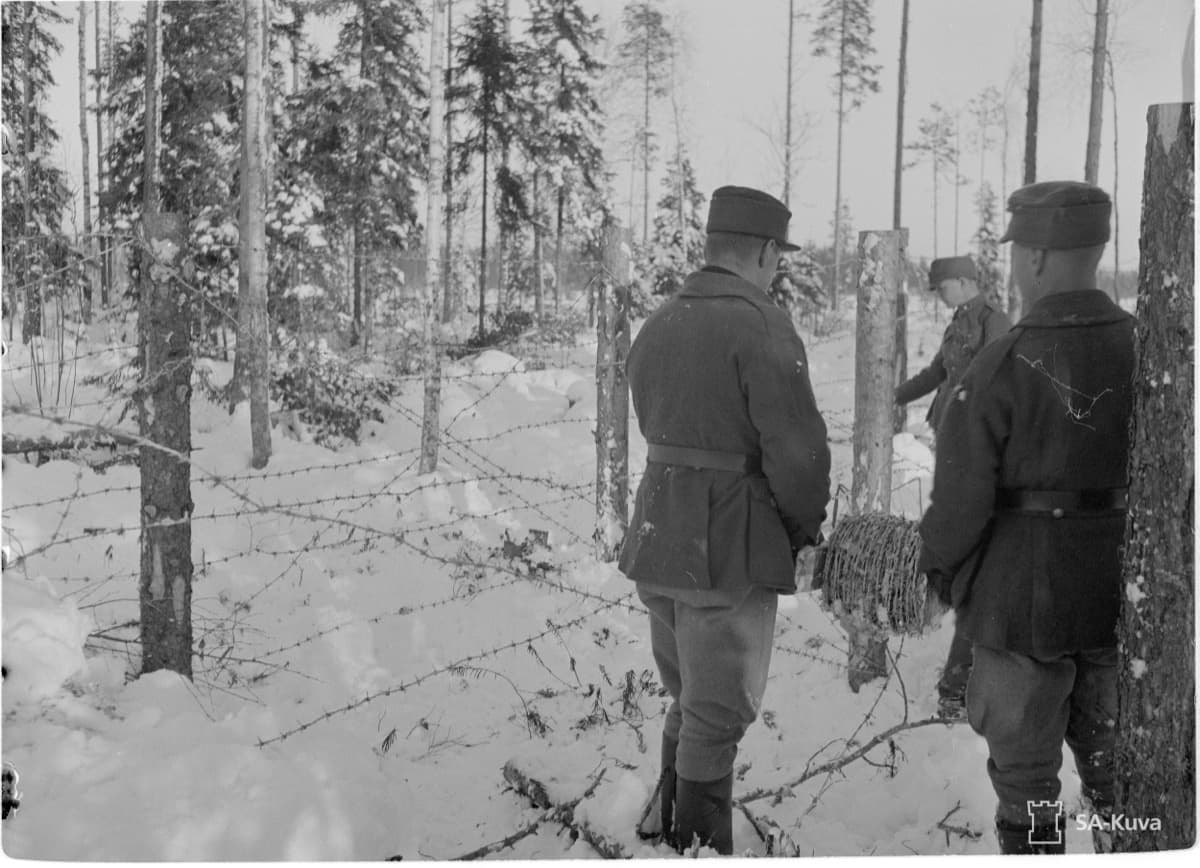 Suomalaisia sotilaita asentamassa piikkilanka-aitaa talvimetsässä